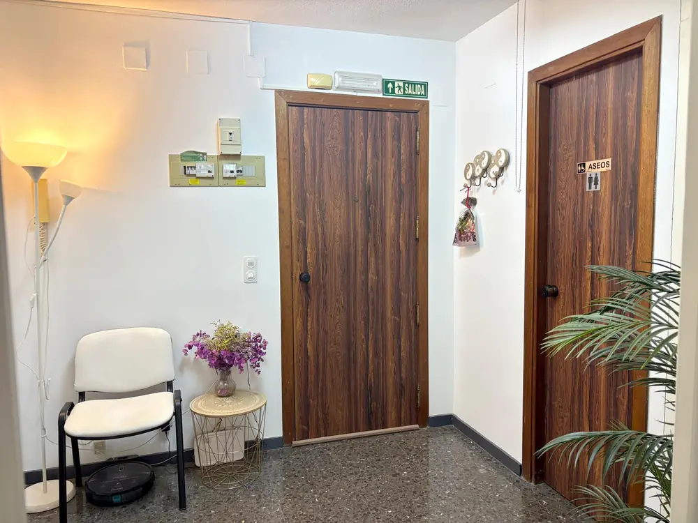 Recepción del centro con una lámpara de pie encendida, flores y una planta
